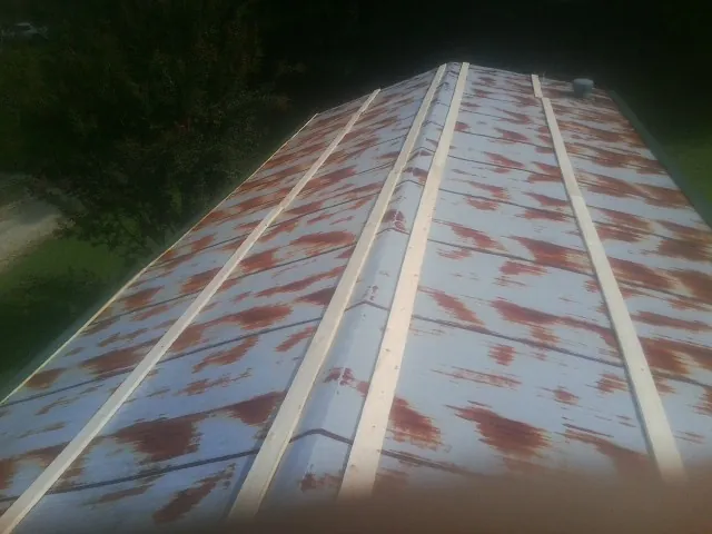 Rusted metal roof panels with new wood purlins before replacement — Storm Damage Roof Repair in Thurmond by Roofing Brothers