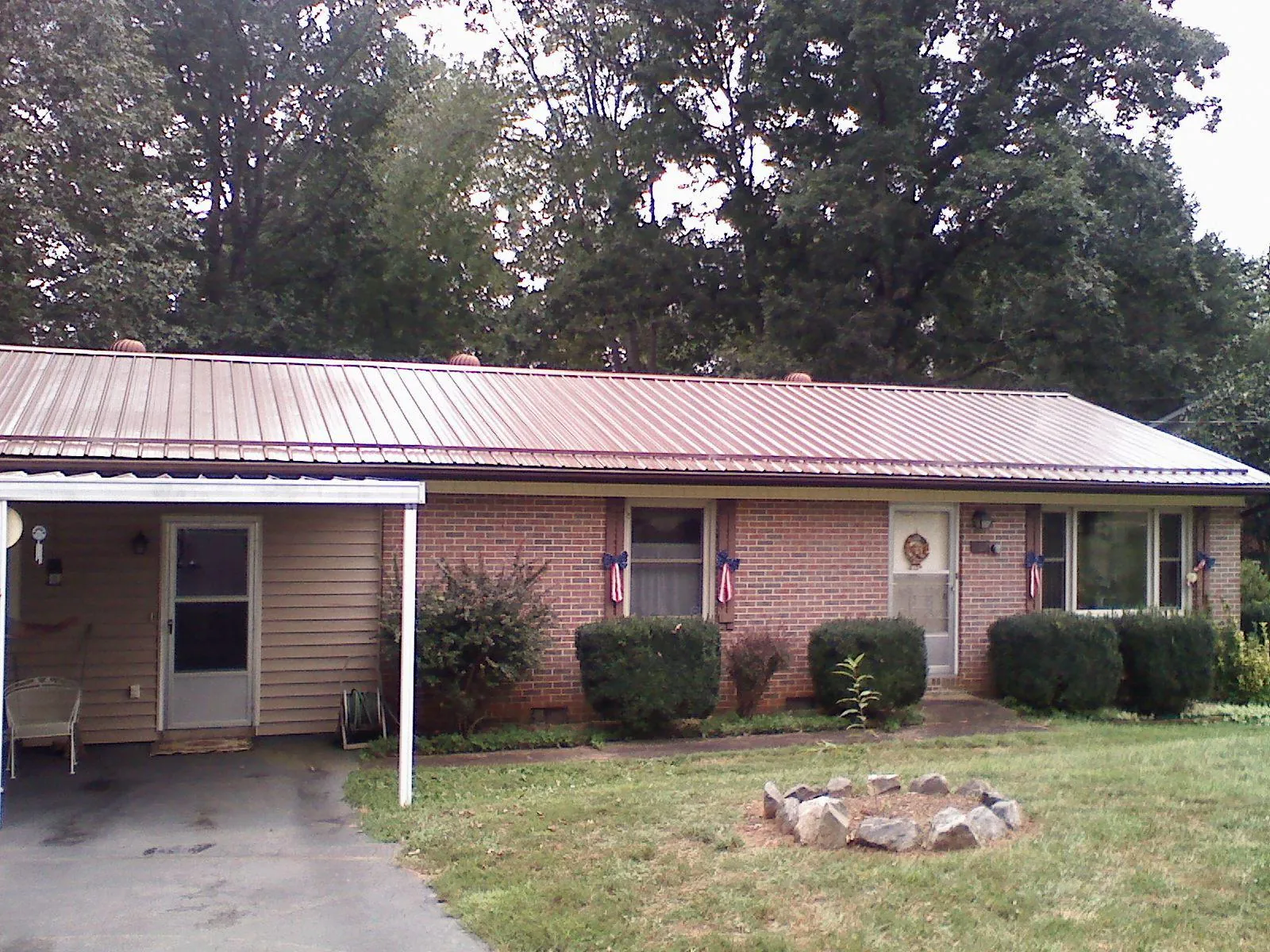 Bronze metal roof and carport on a brick ranch home — Roof Repair work by our crew in Thurmond
